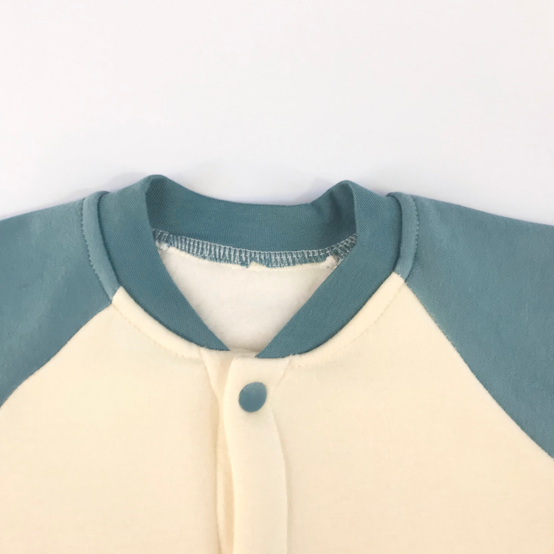 Detalle cuello azul petróleo con forro interior y broche