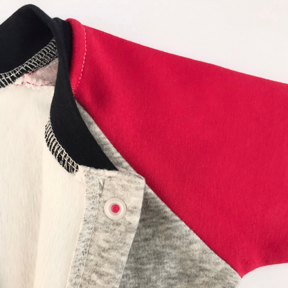 Detalle cuello azul marino y manga raglan roja con broche